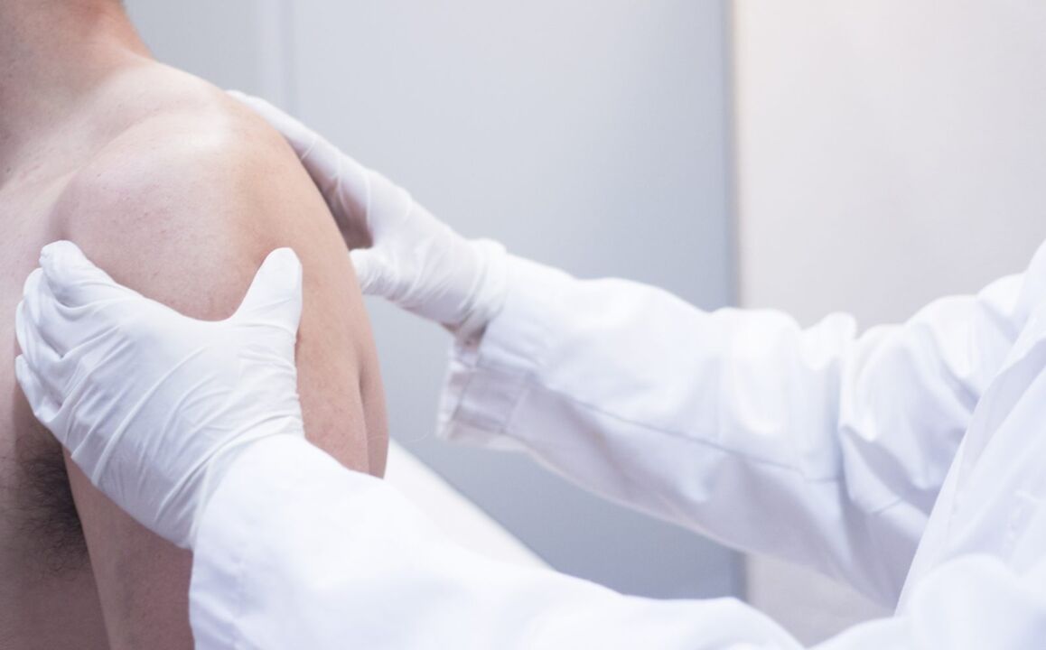 The doctor examines the arthrosis of the shoulder